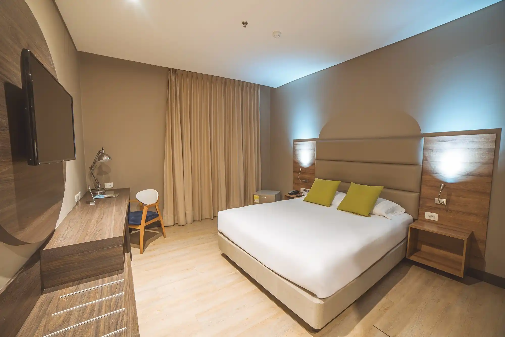 Habitación Sencilla con Balcón del Hotel F25: cama amplia, escritorio y roommates con luz natural.